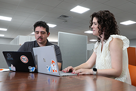 Two medical students conducting research on their laptops.