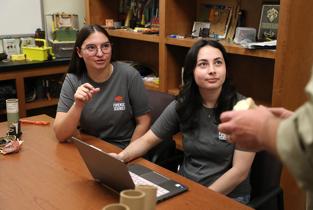 forensic-science-may-2026-002.png Forensic science students in an office speaking with one another.