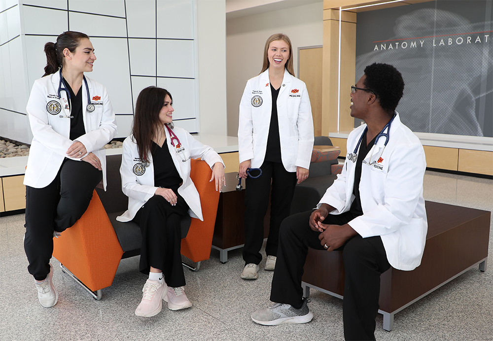 Four students casually talking to each other in the North Hall lobby.