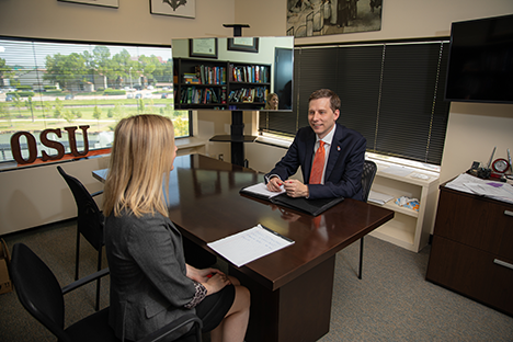 Dr. Beaman and a woman sitting at a desk in an office speaking.