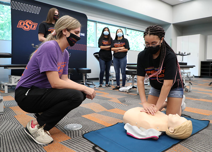 Medical student Emilie Folz (left) helps Zara Trotter with a chest compression exercise during Operation Orange at the Oklahoma State University College of Osteopathic Medicine at the Cherokee Nation in Tahlequah, Oklahoma. Medical student Emilie Folz (left) helps Zara Trotter with a chest compression exercise during Operation Orange at the Oklahoma State University College of Osteopathic Medicine at the Cherokee Nation in Tahlequah, Oklahoma.