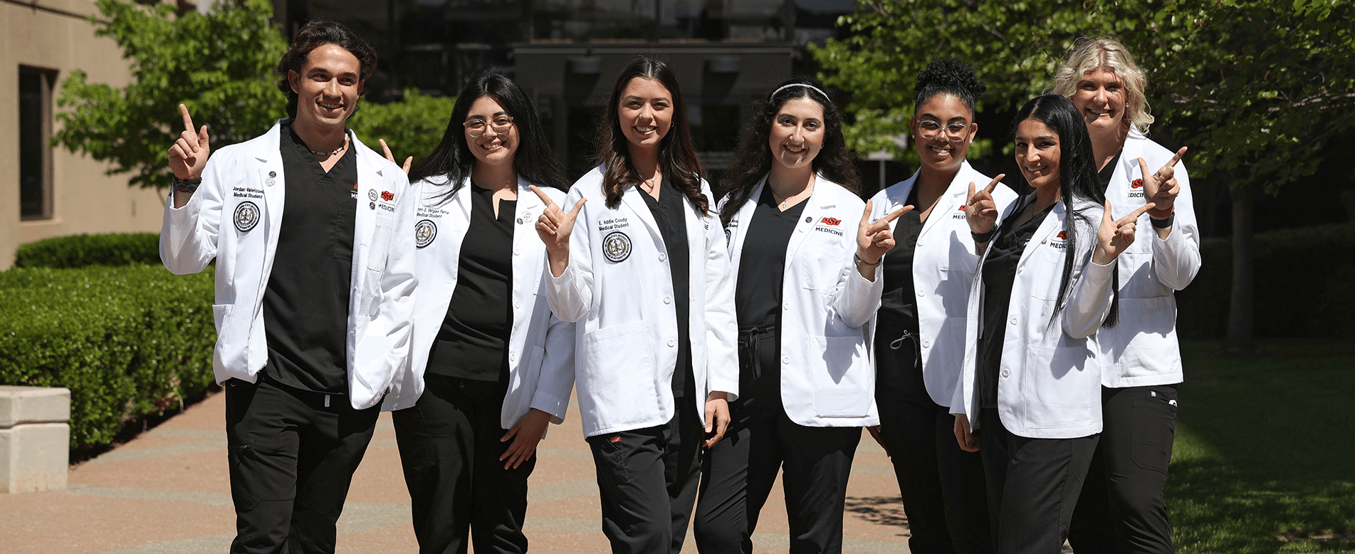 Med students doing the go pokes hand sign
