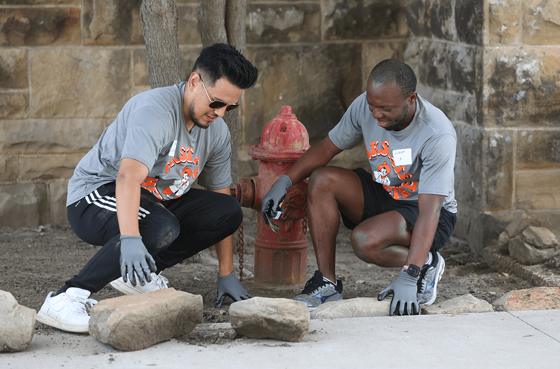 Medical students Chris Coronado (left) and Gilbert Ateh refresh a flowerbed outside Sperry, Okla., town hall. Medical students Chris Coronado (left) and Gilbert Ateh refresh a flowerbed outside Sperry, Okla., town hall.