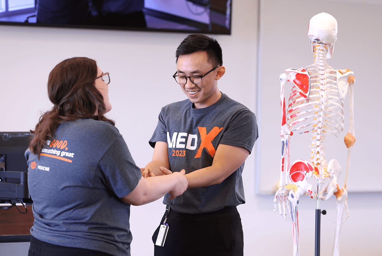 Medical students including Sarah Wilkinson (left) demonstrate Osteopathic manipulative medicine (OMM) during Med-X on the OSU Center for Health Sciences campus in Tulsa, OK. Medical students including Sarah Wilkinson (left) demonstrate Osteopathic manipulative medicine (OMM) during Med-X on the OSU Center for Health Sciences campus in Tulsa, OK.