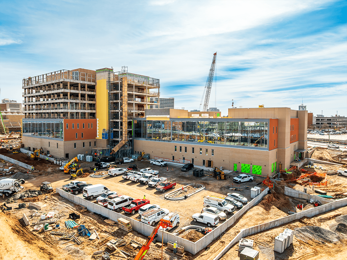 Aerial photo of the construction site of a large building with many glass windows. 